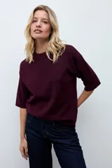 Sweater de punto color ciruela, con cuello redondo, mangas 3/4 y corte holgado.