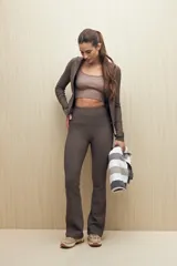 Campera deportiva de textura acanalada, color negro, con cierre frontal, cuello alto y mangas largas con orificio para el pulgar.