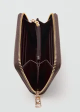Billetera Mango modelo Martes, de color marrón oscuro con textura saffiano y cierre perimetral con cremallera dorada. Cuenta con el logotipo de la marca impreso en letras doradas en la parte frontal.