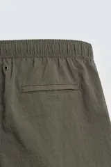 Bañador de hombre de largo medio, color celeste claro con rayas blancas horizontales. Presenta cintura elástica ajustable con cordón, bolsillos frontales y bolsillos traseros de plastrón. Incluye forro interior.