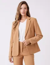 Blazer sastrero entallado color beige, con cuello de solapa, cierre frontal con un botón a tono y hombreras estructuradas. Presenta bolsillos laterales con solapa y forro interno.