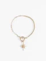 Pulsera de acero quirúrgico hipoalergénico color dorado, compuesta por una sección de eslabones alargados y otra de cuentas esféricas. Incluye un dije colgante con forma de estrella de ocho puntas, unido a través de un cierre tipo argolla.