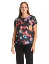 Remera de manga corta con frente estampado con diseño floral multicolor sobre fondo negro y espalda lisa. Presenta cuello redondo a la base y corte recto.