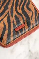 Billetera con cierre de cremallera y estampado animal print de leopardo.