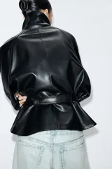 Cazadora de efecto piel con cuello solapa, manga larga con puños y cierre frontal con cremallera. Presenta bolsillos de vivo en el delantero y un cinturón de lazada en el mismo material para ajustar a la cintura.