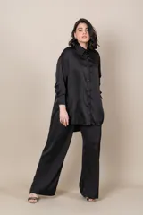 Camisa blanca oversize de satén italiano, con cuello clásico, cierre frontal con botones, mangas largas con puños anchos y tajos laterales.