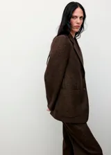 Pantalón de vestir de corte recto y tiro alto, confeccionado en tejido de mezcla de lana con acabado jaspeado. Presenta un diseño largo y cierre de cremallera lateral.