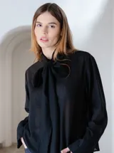 Camisa negra de algodón con cuello con lazo desmontable y mangas largas.