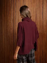 Poleron negro de tejido de punto con cuello alto doble y mangas 3/4 con puños acanalados.