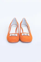 Zapatos de tacón color naranja con herraje de cristal.