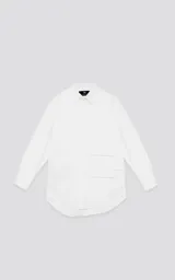 Camisa blanca de manga larga, confeccionada en poplín de algodón, con calce oversize y un bolsillo frontal asimétrico y poco convencional.
