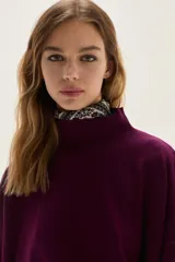 Polera de tejido de punto color azul, con cuello alto, manga larga y puños acanalados.