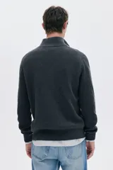 Sweater de punto acanalado color gris oscuro, con cuello alto y cierre frontal parcial metálico.