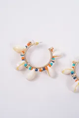 Aros tipo argolla decorados con cuentas de colores fucsia y rosa, intercaladas con pequeñas caracolas naturales y detalles metálicos dorados.