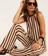 Pantalón de punto color crema con rayas verticales marrones, de corte recto y cintura alta con elástico.