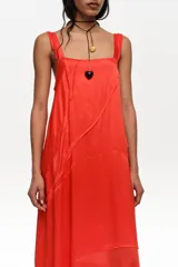 Vestido midi de línea A con vuelo color rojo, confeccionado en mezcla de viscosa y lyocell, con escote cuadrado, tirantes anchos y tiras diagonales decorativas.
