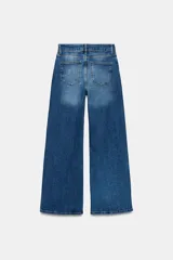 Jeans de tiro alto color marrón, corte wide leg y largo completo. Cuenta con cinco bolsillos, trabillas para cinto y cierre frontal con cremallera y botón metálico.
