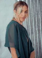 Capa corta color fucsia de gasa, estilo torerita, con mangas amplias y abertura frontal.