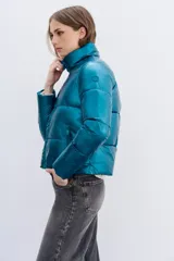 Campera puffer metalizada color verde petróleo, con cuello alto, cierre frontal y bolsillos con cierre.