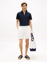 Chomba azul marino de corte regular con cuello tipo chomba y cierre de cremallera de 1/4 con cinta distintiva. Logo de Tommy Hilfiger bordado en la manga.