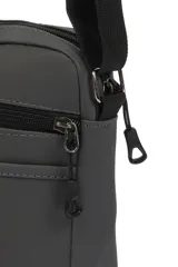 Morral de diseño compacto en color gris oscuro, con cierre principal y bolsillo frontal con cierre. Incluye una etiqueta decorativa con texto en el frente y correa ajustable para llevar al hombro o cruzado.