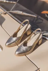 Zapato destalonado de cuero vacuno color blanco, con punta fina, taco ancho y tira elástica ajustable en el talón.