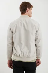 Campera tipo bomber color natural con cierre frontal y cuello, puños y cintura acanalados.