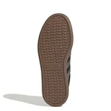 Championes urbanos Adidas modelo Barreda T, color negro con detalles en gris metalizado y suela de goma color marrón. Presentan el diseño clásico de las tres tiras laterales y refuerzos en la puntera.