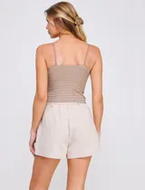 Top crop de punto elastizado color beige, con escote recto y tirantes finos regulables. Presenta una trama texturada con franjas horizontales.
