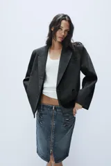 Blazer corto de corte oversize con estampado de cuadros, cuello con solapa de muesca, manga larga y cierre frontal cruzado con un botón. Cuenta con bolsillos decorativos de vivo en el frente y forro interior.