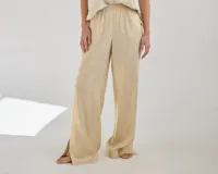 Pantalon de corte recto y tiro medio, confeccionado en lino, con cintura elastizada y tajos laterales en el ruedo.