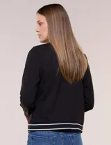 Cardigan tipo varsity negro de punto liviano, con cuello redondo, mangas largas y cierre frontal de botones. Presenta detalles de líneas blancas en el cuello, los bolsillos simulados y el ruedo elástico acanalado.