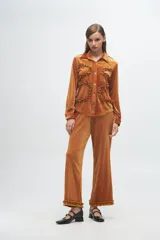 Pantalón de terciopelo rib lurex color gris, de corte recto y holgado, con detalle de volados en el ruedo.