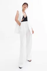 Pantalón negro de vestir de corte palazzo con cintura alta y bolsillos laterales.