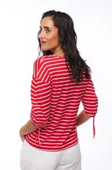 Remera a rayas horizontales rojas y blancas, con escote en V y mangas 3/4 con jaretas regulables.