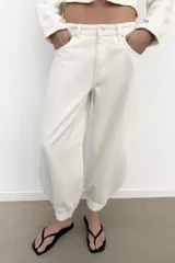 Jeans negro de tiro medio con corte balloon fit, diseño de cinco bolsillos y bajo acabado en puño con abertura y botón.