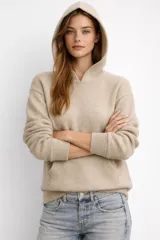 Canguro de tejido de punto color beige, con capucha, manga larga y bolsillo frontal tipo canguro. Presenta puños y ruedo acanalados.