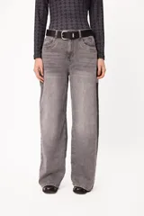 Jean wide leg de tiro medio con efecto lavado en color gris. Presenta un corte holgado de pierna ancha, cierre frontal con botón y cremallera, y bolsillos laterales. Incluye un pequeño bordado distintivo en la zona del bolsillo.