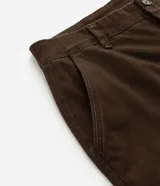 Bermuda masculina slim confeccionada en sarga de algodón con elastano, color beige, con bolsillos laterales tipo chino, bolsillos traseros embutidos con botón, trabillas en la cintura y cierre frontal con botón y cremallera.
