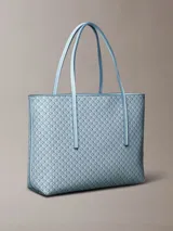 Cartera tote pequeña y estructurada de Calvin Klein en color celeste, con estampado integral de monograma CK. Incluye asas de mano dobles y una cartera mini interior a juego con cierre superior.