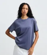 Remera de corte boxy con cuello redondo y mangas cortas. Confeccionada en algodón, presenta un diseño minimalista sin estampas con sisa caída.