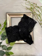 Bombacha tipo hipster de tiro alto confeccionada íntegramente en encaje negro con diseño floral. Presenta un calce que moldea la silueta y cuenta con forro interior de algodón.