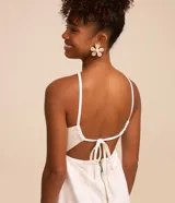 Mono largo blanco de sarga con escote en pico, tirantes finos, lazo en la espalda y cierre con cremallera.