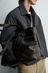 Cazadora relaxed fit de algodón color gris oscuro, con cuello solapa, manga larga con puños abotonados, bolsillos de plastrón en el pecho y cierre frontal con botonadura.