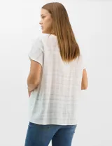 Blusa de corte fluido confeccionada en algodón con tejido texturizado de patrón a cuadros. Presenta mangas cortas caídas, escote redondo y cierre frontal con botones.