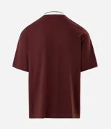 Remera de corte boxy confeccionada en piqué de algodón color bordó. Presenta cuello polo en color blanco con detalles en contraste, mangas cortas y estampa frontal con diseño gráfico y lettering en color blanco.