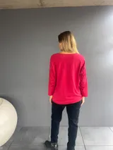 Blusa de manga larga color rojo borgoña, con cuello redondo y diseño holgado de textura ligeramente arrugada.