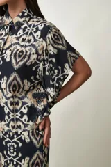 Camisa Girasol de manga corta color negro, con cuello camisero, cierre frontal de botones y mangas con volados drapeados.