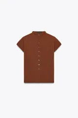 Top de tejido de punto color marrón óxido, manga corta y cuello mao con cierre frontal de botones.