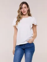 Remera blanca semi entallada de algodón con elastano, escote redondo y mangas cortas estilo tulipán confeccionadas en broderie calado con bordados florales y terminación festonada.